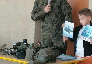 Żołnierz opowiada o helikopterach widocznych na zdjęciach.
