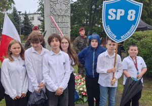 Uczniowie SP 8 stoją przy pomniku Zesłańców Sybiru