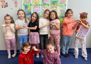Dziewczynki z "zerówki" stoją na tle prac plastycznych poświęconych Dniu Życzliwości