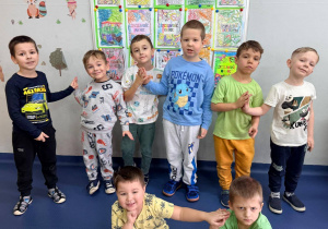 Chłopcy z "zerówki" stoją na tle prac plastycznych poświęconych Dniu Życzliwości