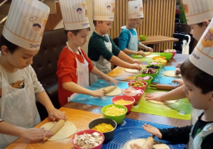 Pierwszoklasiści przygotowują swoje pizze