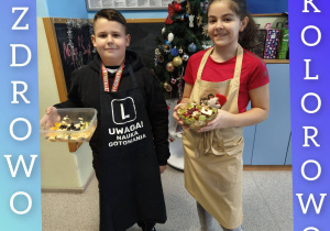 Uczniowie trzymają w rekach miski z owocowyymi sałatkami