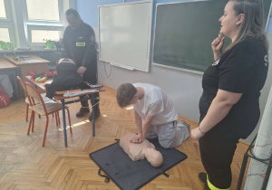 Uczeń na fantomie wykonuje resustytację krążeniowo – oddechową.