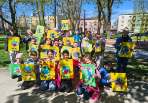 Uczniowie trzymają plakaty poświęcone Dniu Ziemi