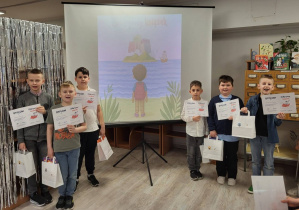 Dzieci pozują z dyplomami za udział akcji czytelniczej „Klub Odkrywców Książek”.