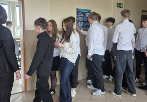 Uczniowie klasy VIII b, zgromadzeni przed salą egzaminacyjną oczekują na rozpoczęcie egzaminu ósmoklasisty
