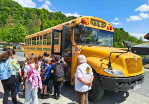 Dzieci wsiadają do amerykańskiego schoolbusa.
