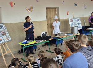 Uczniowie z zainteresowaniem słuchają gości podczas II Festiwalu Zawodów, poznając tajniki pracy policjanta, kucharza i stylistki paznokci.
