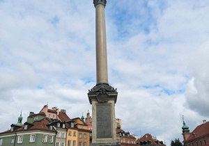 Uczniowie klasy II stoją przed Kolumną Zygmunta na warszawskim Placu Zamkowym.