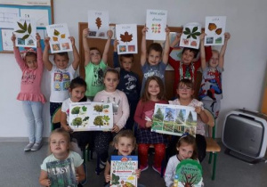 Na fotografii dzieci przedstawiają przygotowane materiały podczas zajęć