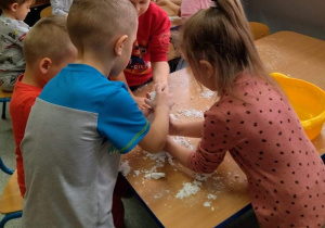 Dzieci tworzą śnieg z mąki i oleju